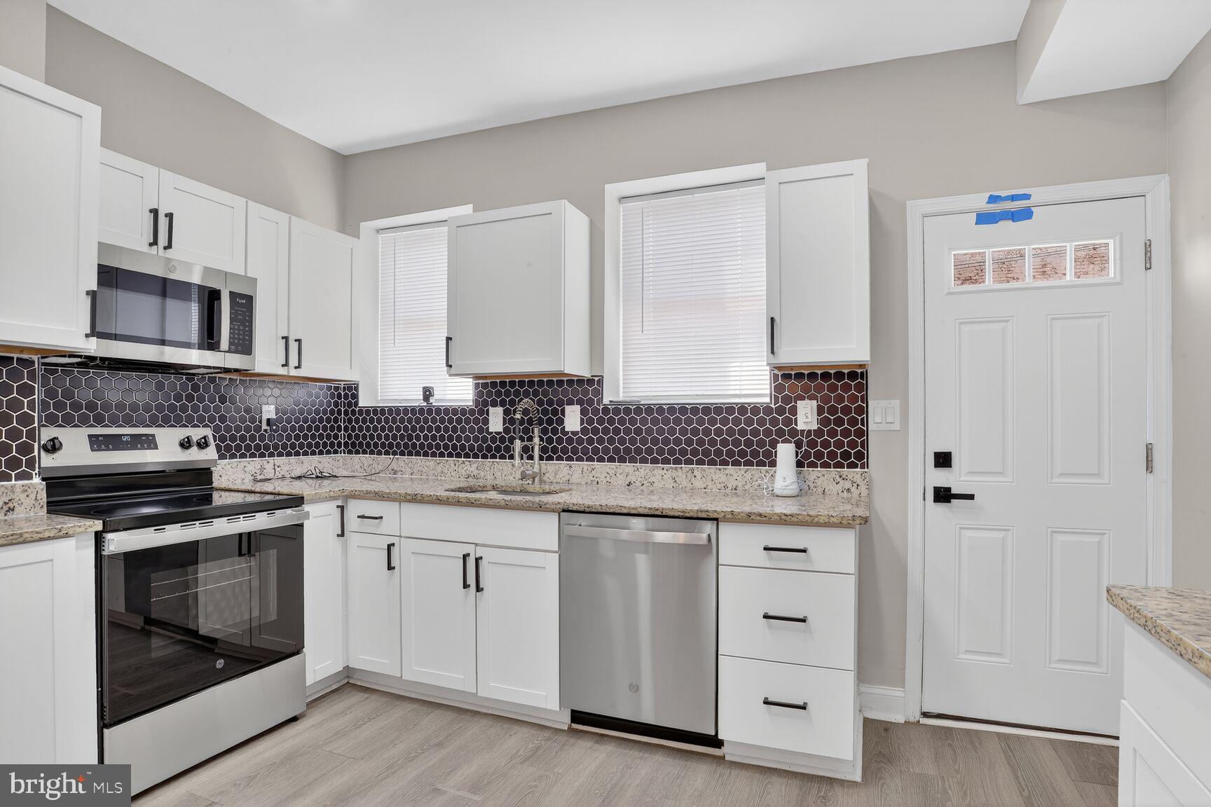 1106 South Carey Street Baltimore, MD 21223 - Photo 9 of 24 a kitchen with white cabinets and stainless steel appliances