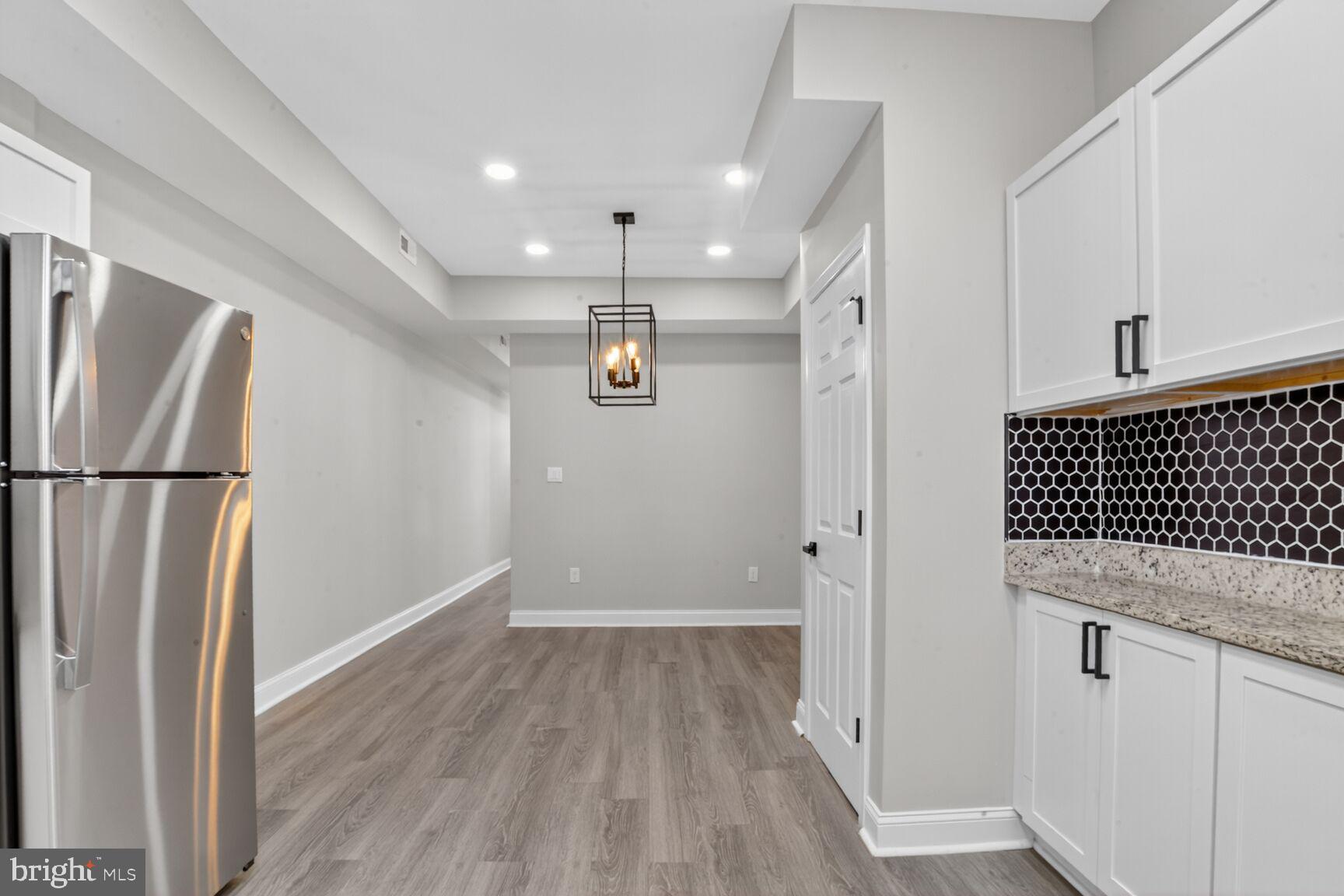 1106 South Carey Street Baltimore, MD 21223 - Photo 10 of 24 a view of a refrigerator in kitchen and wooden floor