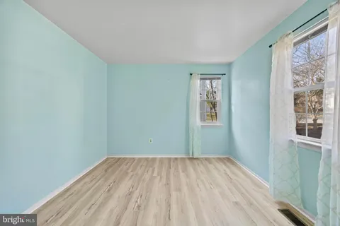 a view of a big room with wooden floor and a bathroom