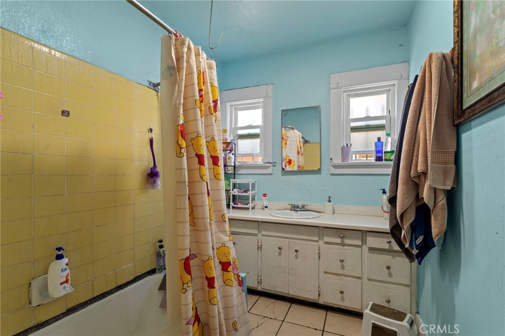 224 West 14th Street Long Beach, CA 90813 - Photo 11 of 28 a bathroom with a sink a mirror and a shower