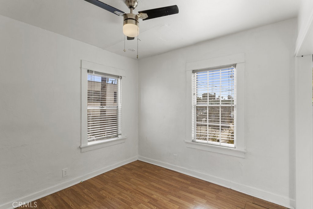 224 West 14th Street Long Beach, CA 90813 - Photo 19 of 28 an empty room with wooden floor chandelier fan and windows