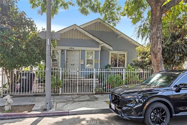 a view of a house with a small yard and wooden fence