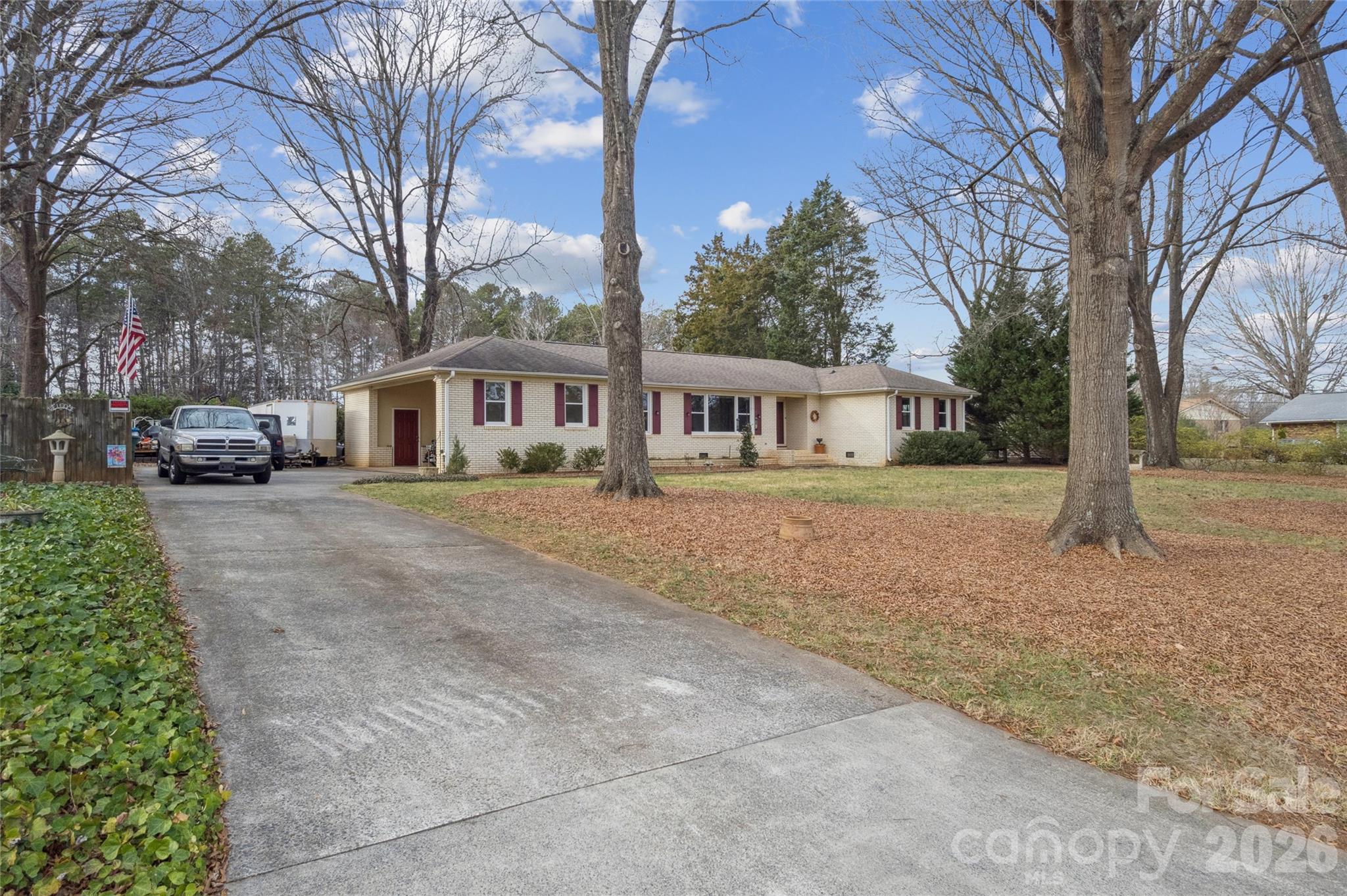 a front view of a house with a yard and trees