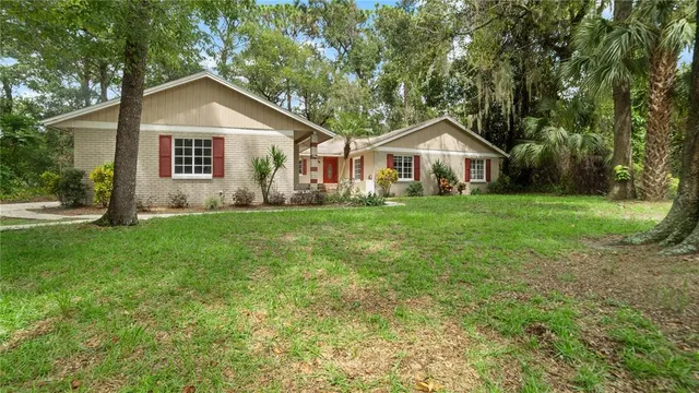 a front view of a house with a yard and trees
