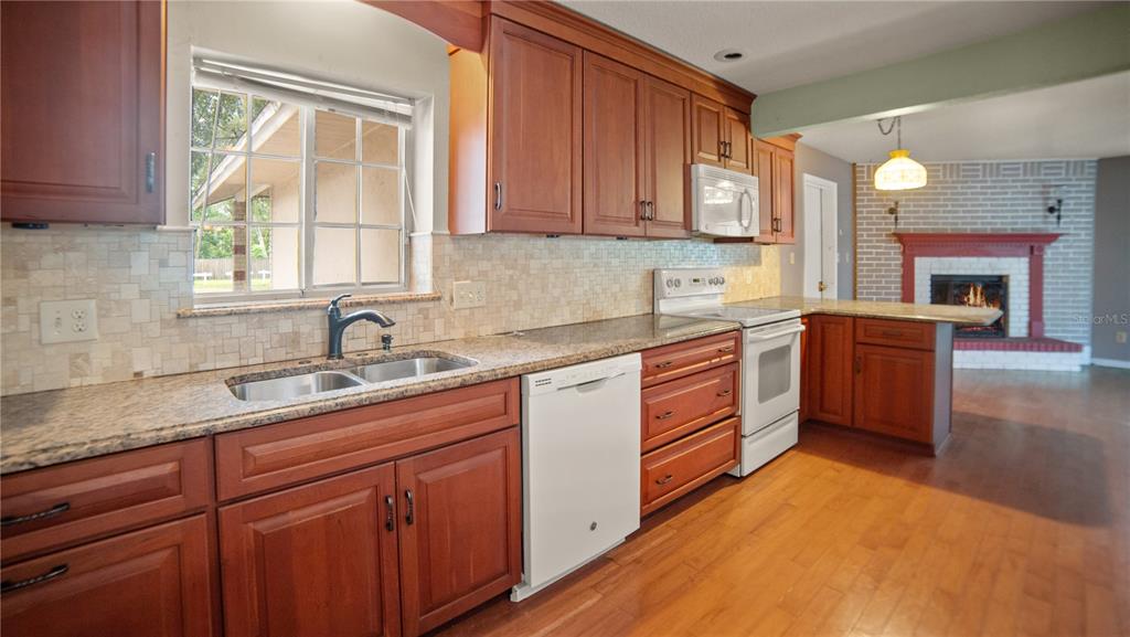 135 East Citrus Street Altamonte Springs, FL 32701 - Photo 10 of 33 a kitchen with stainless steel appliances granite countertop a sink a stove cabinets counter space and a window