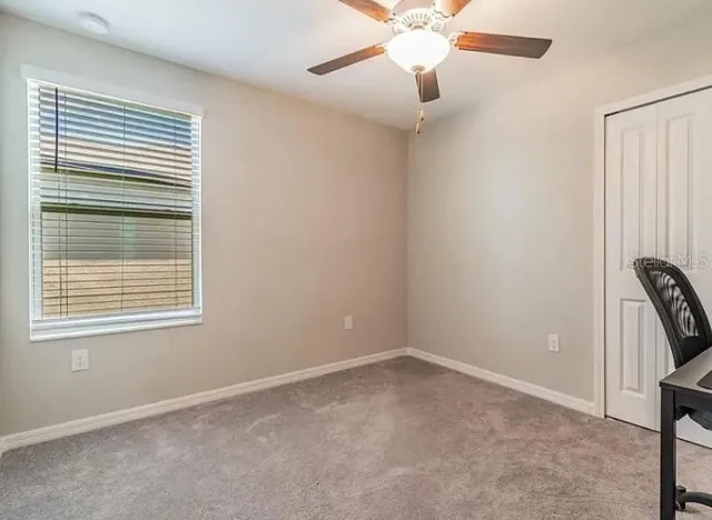 en empty room with windows and fan