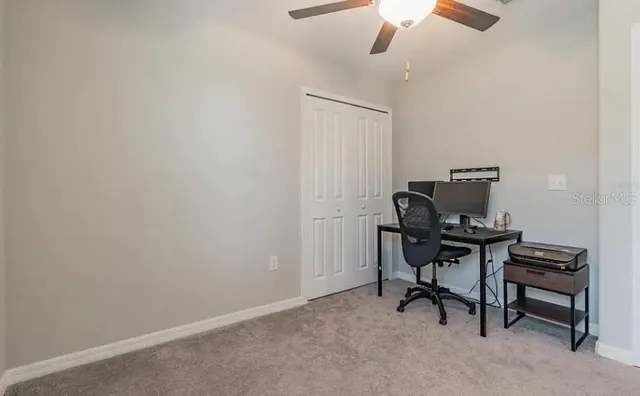 a view of a workspace with furniture and a window