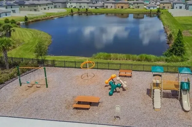 an aerial view of a house with a yard and lake view