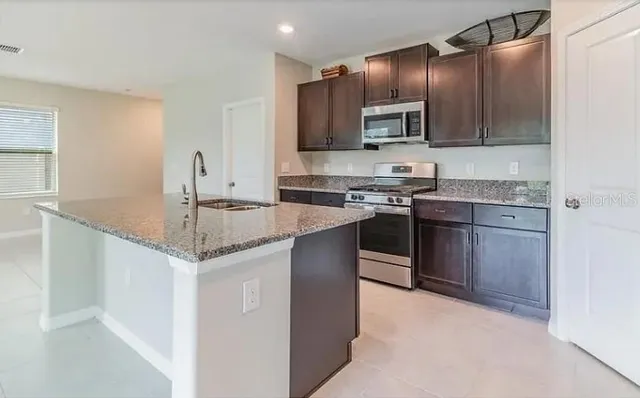 a kitchen with stainless steel appliances granite countertop a sink stove and cabinets
