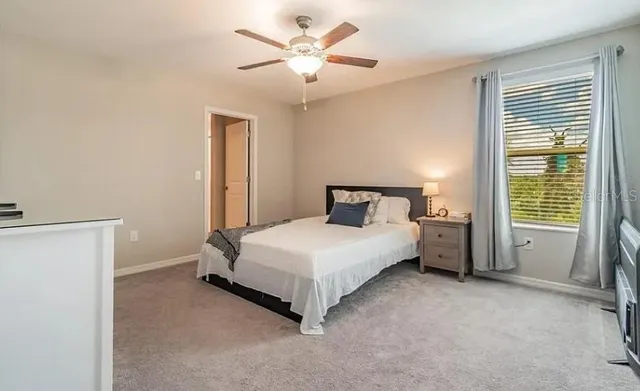 a bedroom with a bed and a ceiling fan