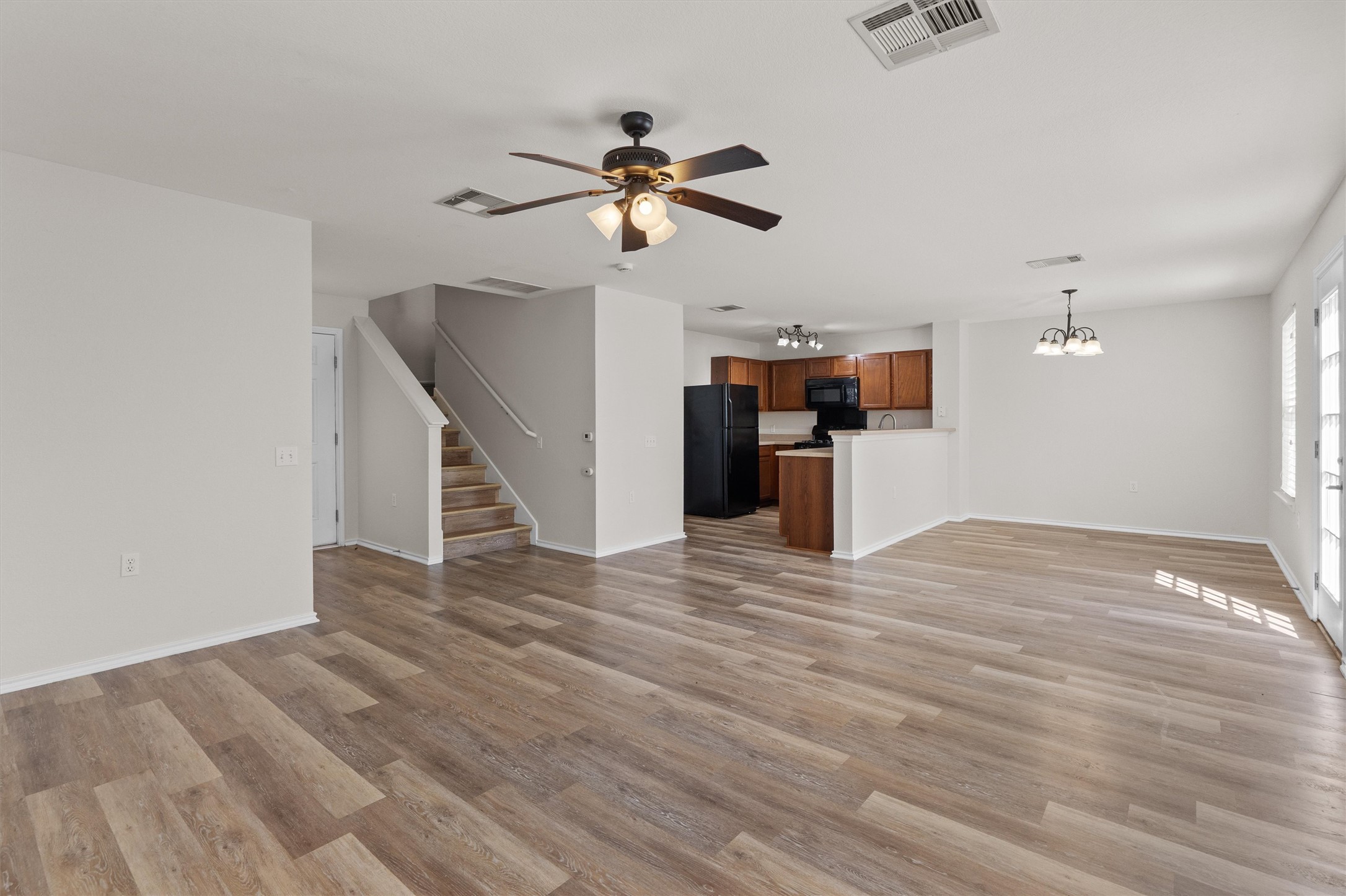 5825 Silver Screen Drive Austin, TX 78747 - Photo 39 of 40 An open floor plan with warm-toned flooring connects living, dining, and kitchen areas for effortless daily life.