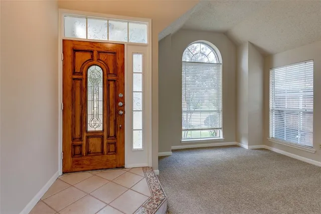 an empty room with windows wooden floor and brick walls