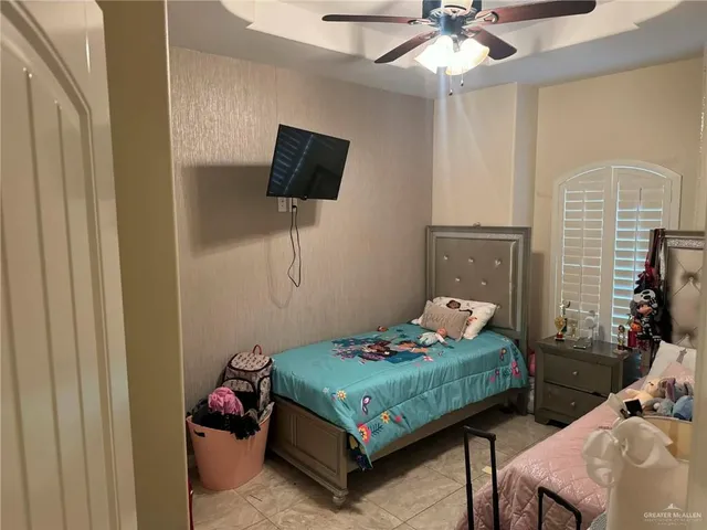 a bedroom with a bed a flat screen tv and chandelier