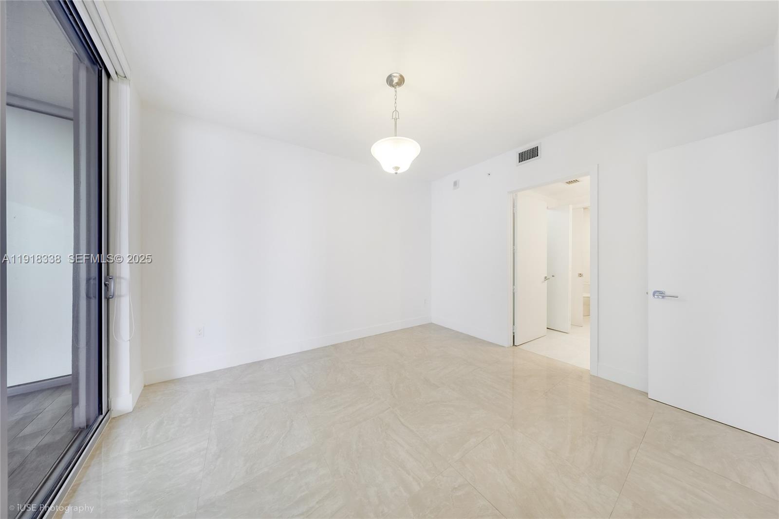 488 Northeast 18th Street, Unit 2304 Miami, FL 33132 - Photo 13 of 41 an empty room with chandelier fan and windows