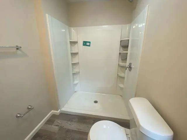 a bathroom with a toilet and a shower