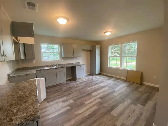a kitchen with granite countertop a stove a sink and a microwave