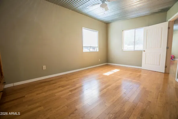 an empty room with wooden floor and windows