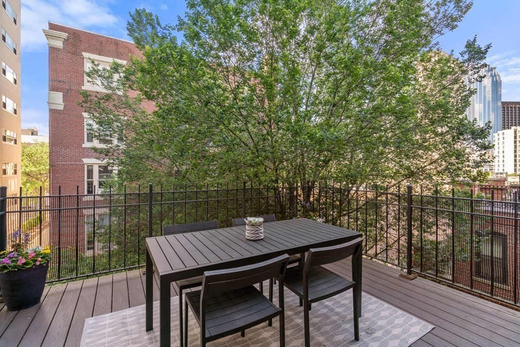 203 St Botolph Street, Unit 4 Boston, MA 02115 - Photo 13 of 26 a view of a patio with table and chairs and wooden floor