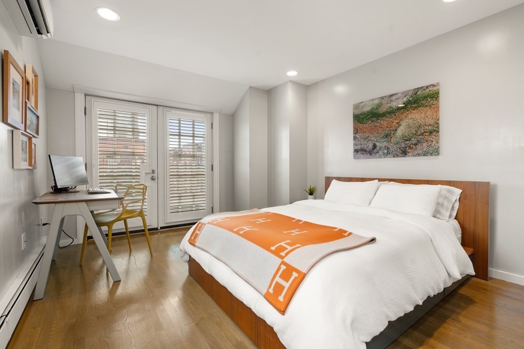 203 St Botolph Street, Unit 4 Boston, MA 02115 - Photo 16 of 26 a spacious bedroom with a bed a table and a flat screen tv