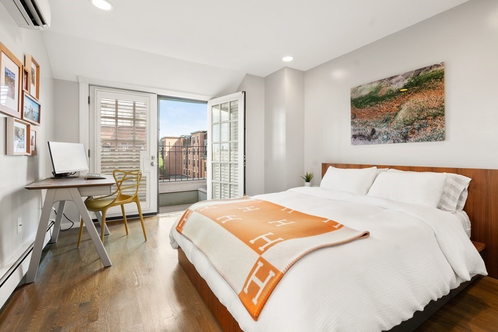 203 St Botolph Street, Unit 4 Boston, MA 02115 - Photo 17 of 26 a bedroom with a large bed a large window and wooden floor