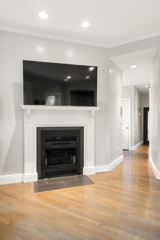 203 St Botolph Street, Unit 4 Boston, MA 02115 - Photo 8 of 26 a view of an empty room with wooden floor and a fireplace