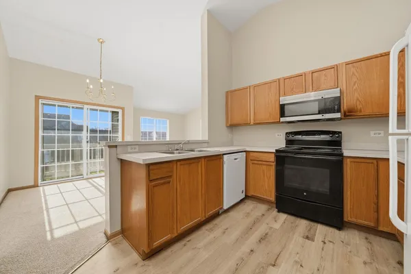 a kitchen with stainless steel appliances granite countertop a stove a sink and a microwave