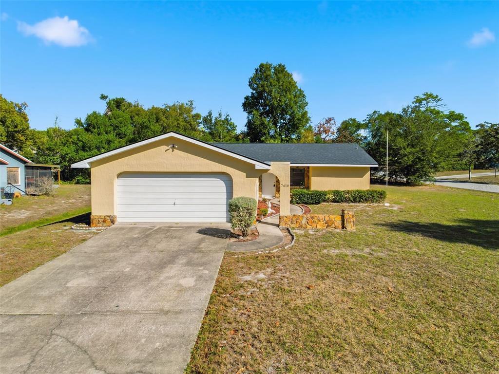 a view of a house with backyard and trees