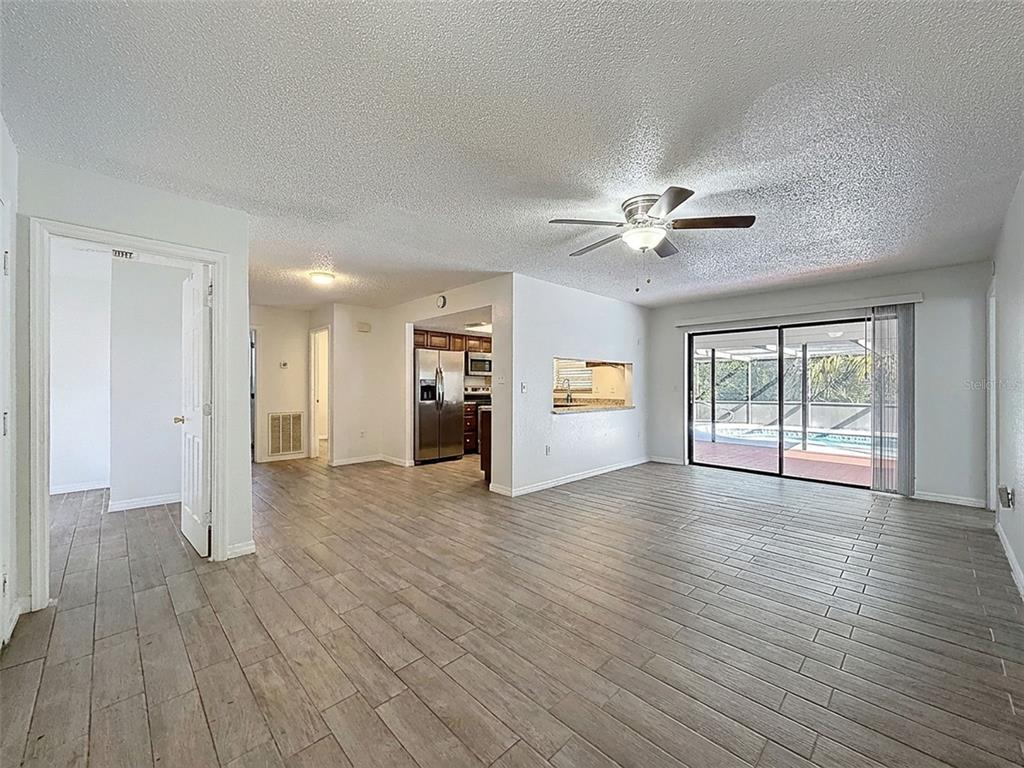 7410 Dundee Court Weeki Wachee, FL 34613 - Photo 13 of 33 a view of an empty room with window and wooden floor