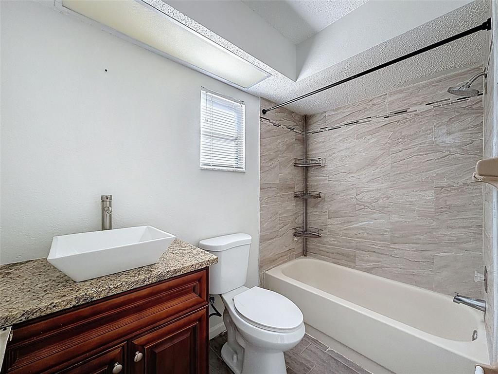 7410 Dundee Court Weeki Wachee, FL 34613 - Photo 20 of 33 a bathroom with a granite countertop sink toilet and shower