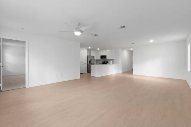 a view of an empty room with a kitchen