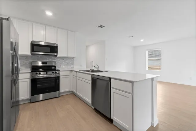 a kitchen with stainless steel appliances a stove and a microwave