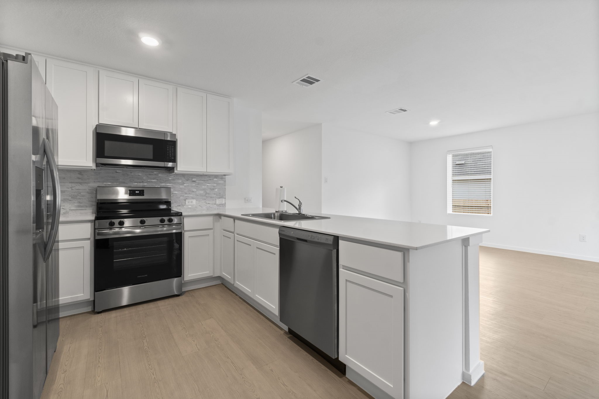 16031 Tallis Drive Conroe, TX 77303 - Photo 19 of 46 a kitchen with granite countertop a refrigerator and a stove top oven