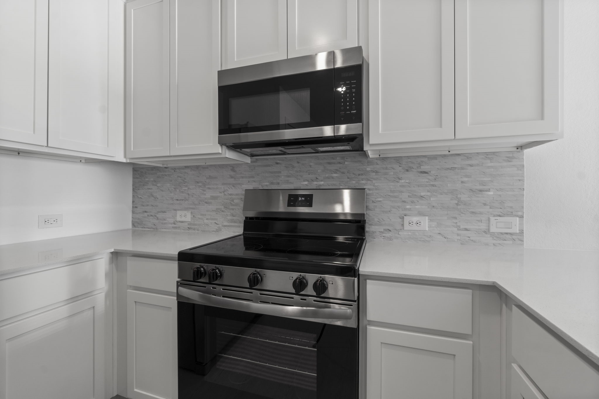 16031 Tallis Drive Conroe, TX 77303 - Photo 20 of 46 a kitchen with stainless steel appliances a stove and a microwave