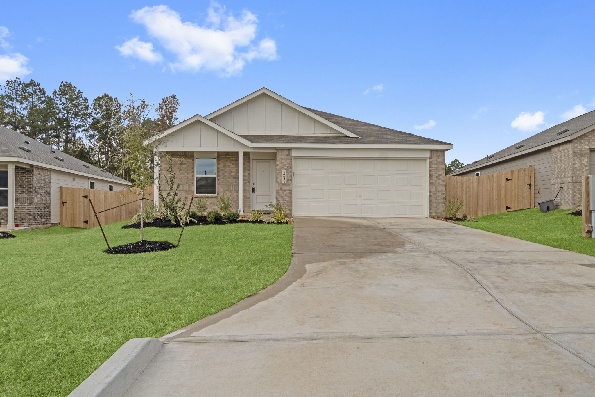 16031 Tallis Drive Conroe, TX 77303 - Photo 2 of 46 a front view of a house with a garden and yard