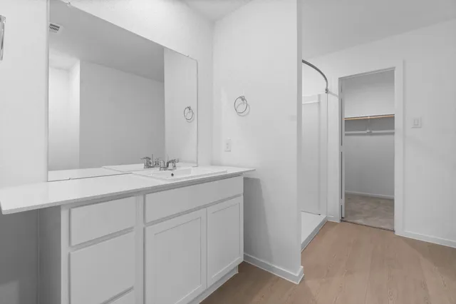 a bathroom with a sink and glass door shower