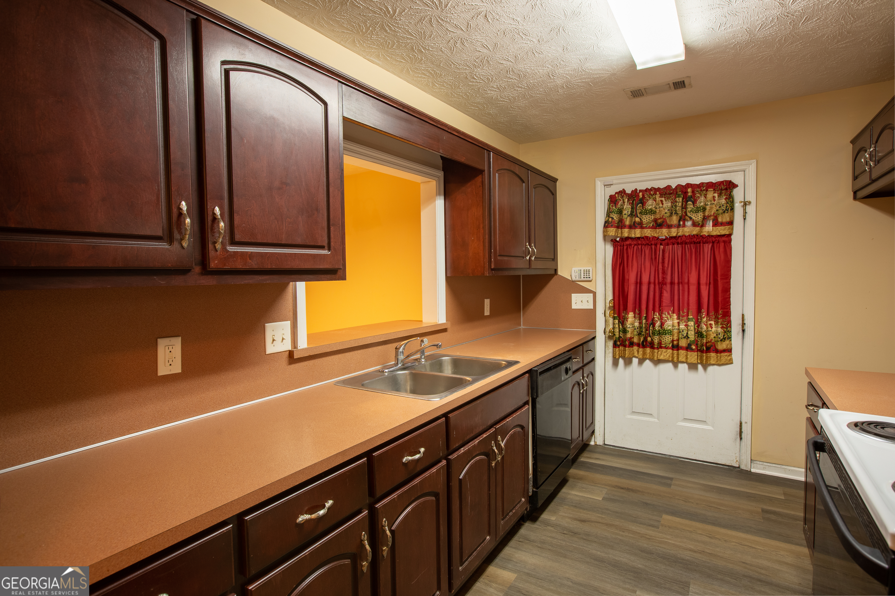 2801 8th Street Columbus, GA 31906 - Photo 8 of 20 a kitchen with stainless steel appliances a sink dishwasher a stove a refrigerator and wooden cabinets