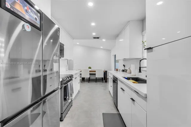 a kitchen with white cabinets and stainless steel appliances