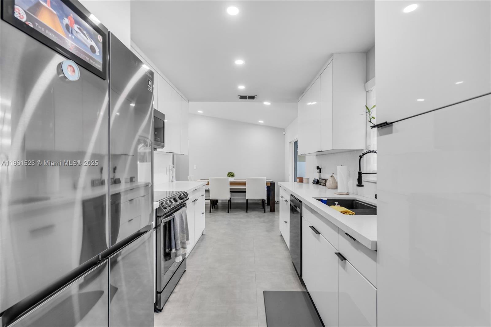 1120 Southwest 128th Drive Davie, FL 33325 - Photo 11 of 38 a kitchen with white cabinets and stainless steel appliances