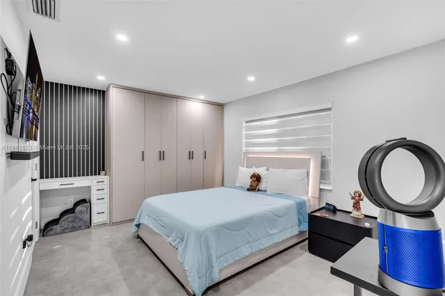 a bedroom with a large bed and a chandelier