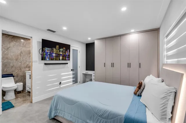 a bedroom with a bed and a flat screen tv