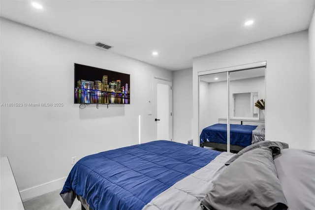 a bedroom with a large bed and a large mirror