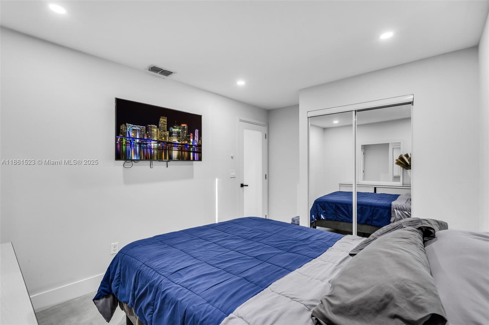 1120 Southwest 128th Drive Davie, FL 33325 - Photo 22 of 38 a bedroom with a large bed and a large mirror