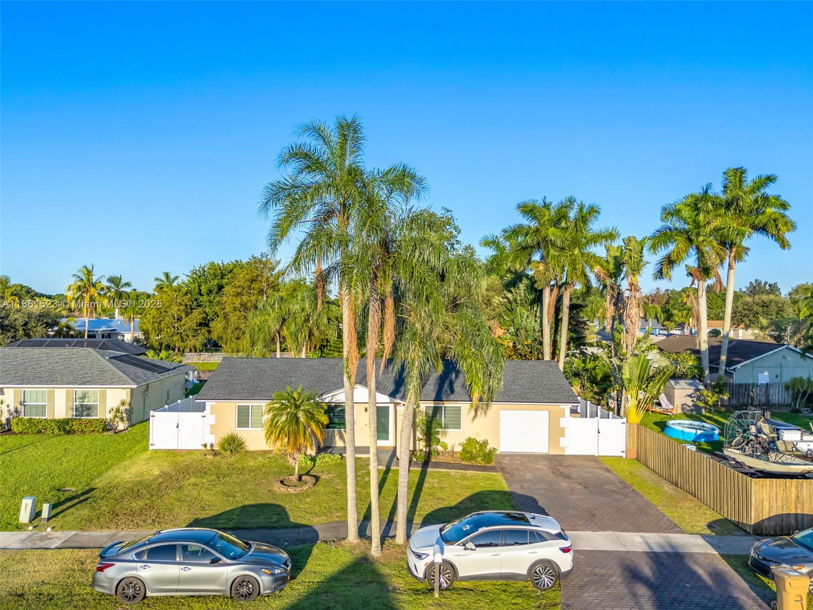 1120 Southwest 128th Drive Davie, FL 33325 - Photo 31 of 38 a view of a swimming pool with a lawn chairs under palm trees