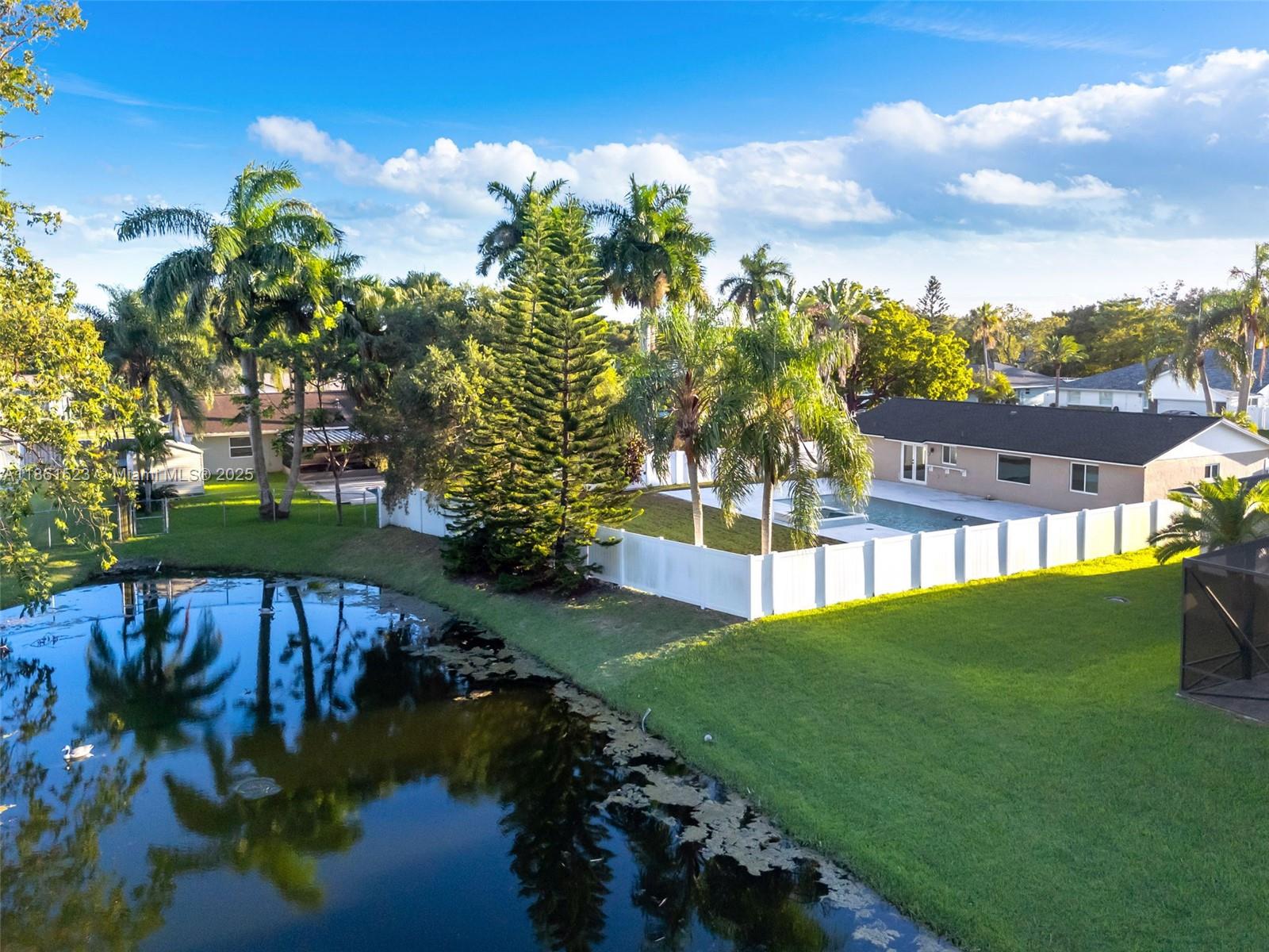 1120 Southwest 128th Drive Davie, FL 33325 - Photo 37 of 38 a view of a lake with a house in the background