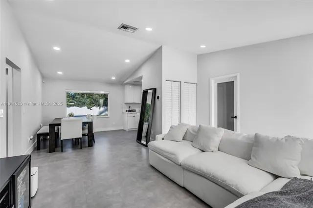a living room with furniture a window and a flat screen tv