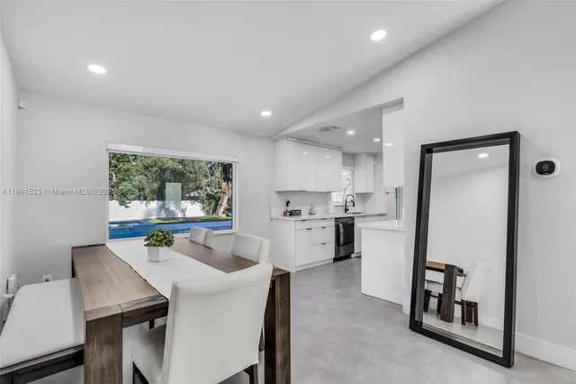 a kitchen with a table chairs refrigerator and a window