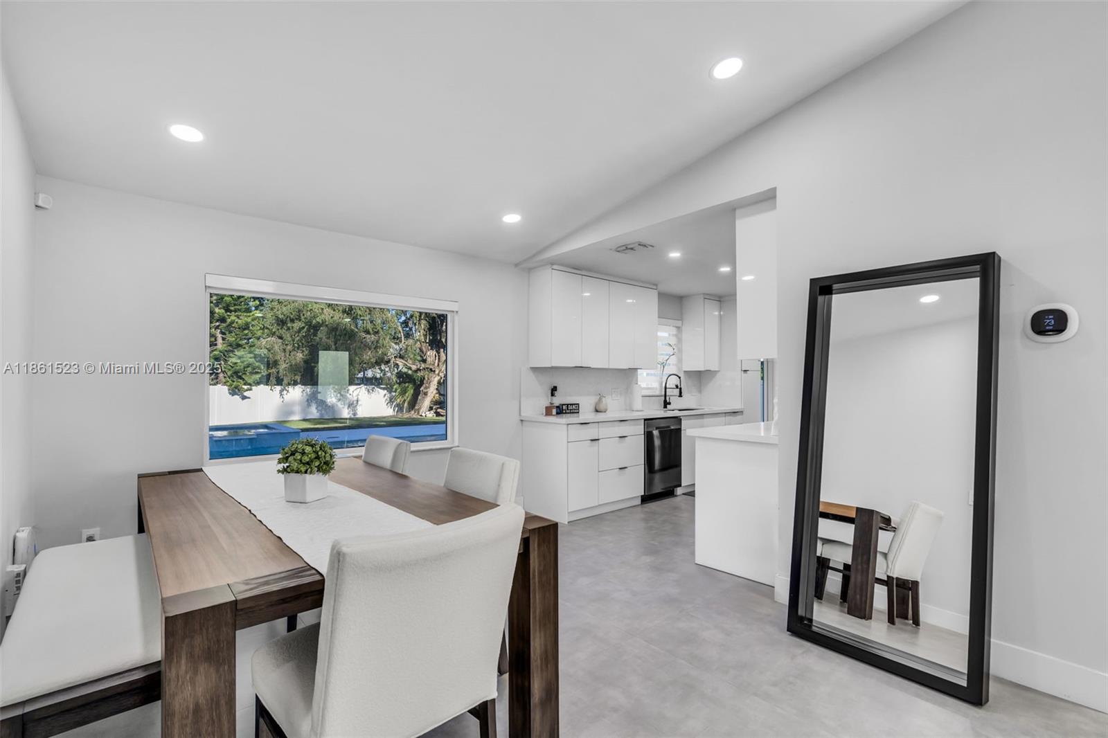 1120 Southwest 128th Drive Davie, FL 33325 - Photo 7 of 38 a kitchen with a table chairs refrigerator and a window
