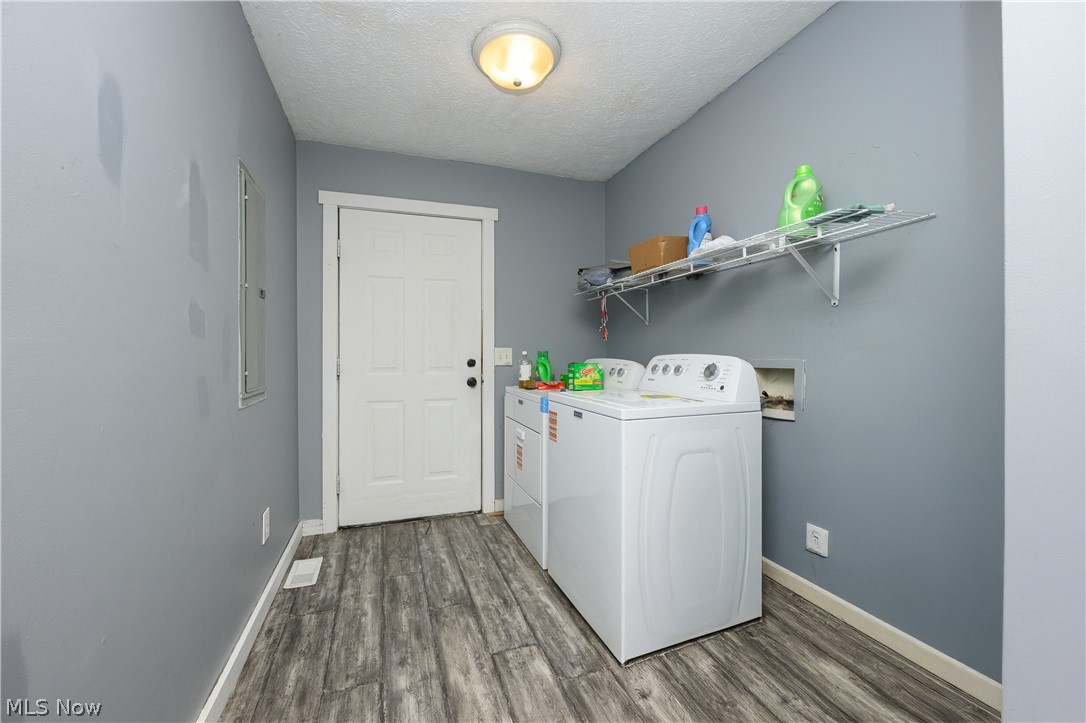 8200 Cutler Road Southwest Sherrodsville, OH 44675 - Photo 17 of 26 Laundry room with dark wood finished floors, separate washer and dryer, and a textured ceiling