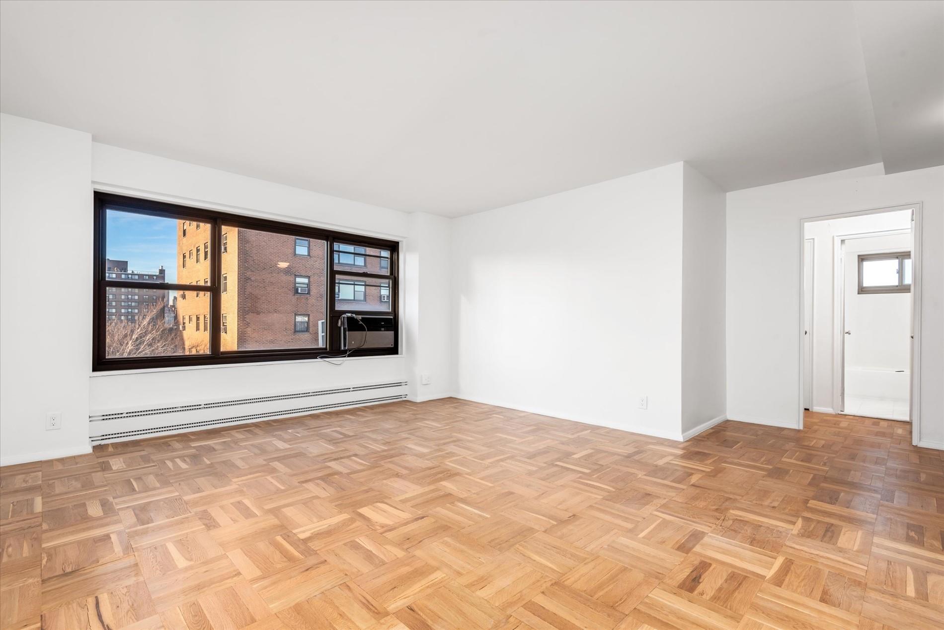 21-36 33rd Road, Unit 7B Queens, NY 11106 - Photo 1 of 1 Spare room featuring baseboards, a healthy amount of sunlight, and baseboard heating