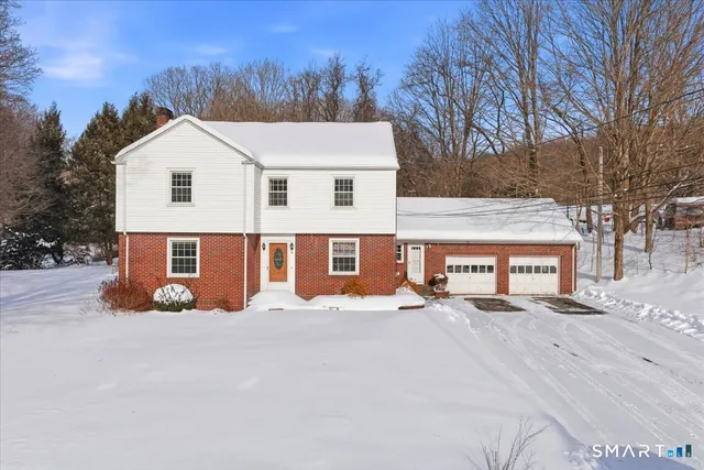 a view of a white house with a yard covered in snow